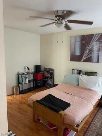 Bedroom with hardwood / wood-style floors and ceiling fan