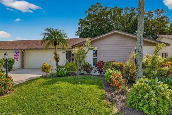 Ranch-style house with a garage, a front yard, concrete driveway, and roof with shingles
