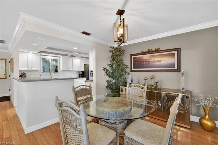 Dining area with crown molding, light wood-type flooring, and recessed lighting