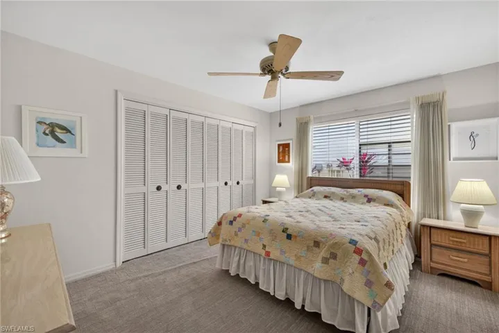 Carpeted bedroom with a closet and ceiling fan