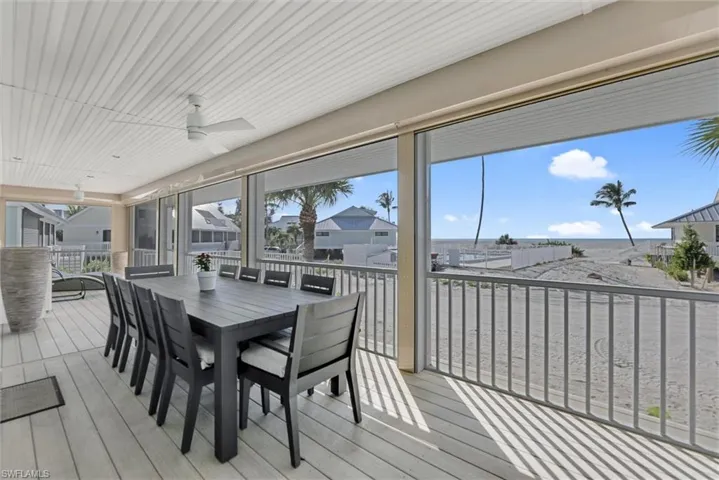 Sunroom / solarium featuring a ceiling fan, outdoor dining space, and a deck