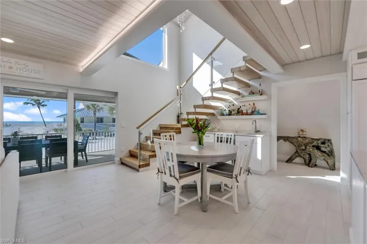 Dining space with stairway, wood ceiling, recessed lighting, a high ceiling, and light wood-style floors
