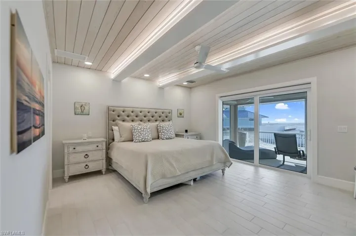 Bedroom with a wooden ceiling with exposed beams, light wood-style flooring, access to exterior, and a ceiling fan