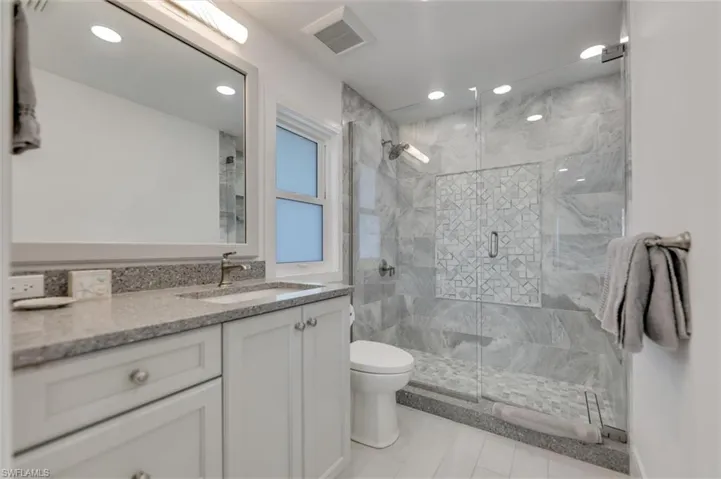Bathroom featuring vanity, a shower stall, and recessed lighting