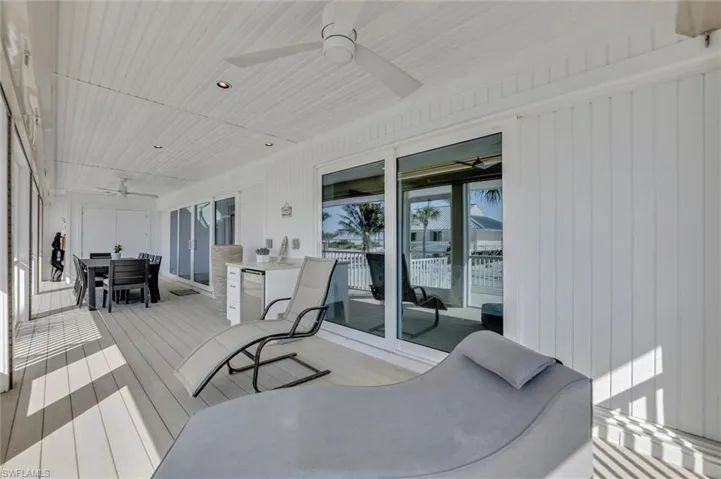 Wooden terrace featuring ceiling fan and outdoor dining area