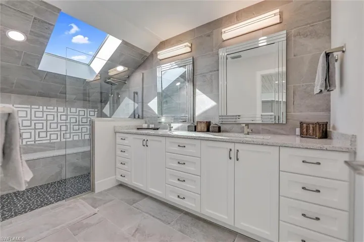 Full bath featuring double vanity and walk in shower