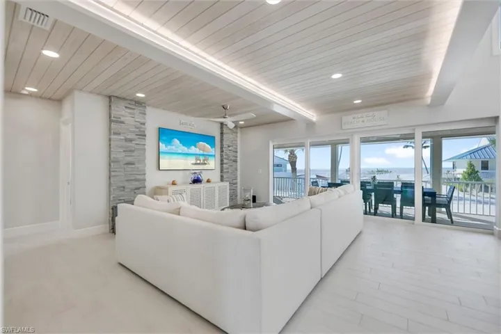 Living area with a wooden ceiling with exposed beams, recessed lighting, and a ceiling fan