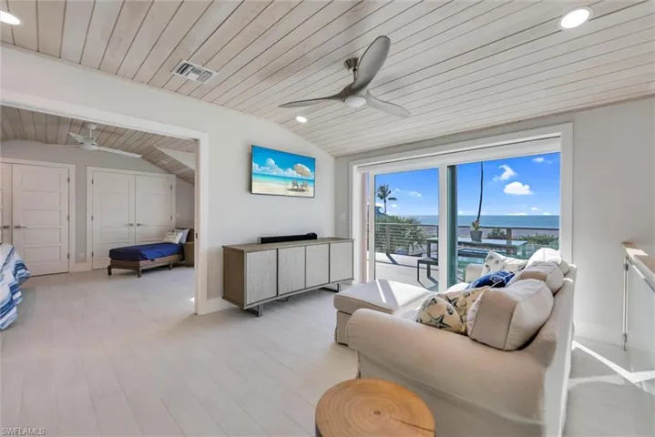 Living area with wooden ceiling, vaulted ceiling, a ceiling fan, and wood finished floors