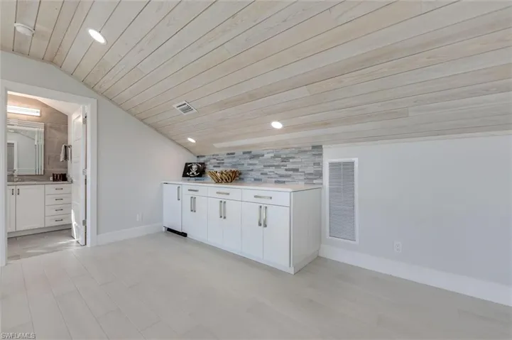 Bar area with white cabinetry, vaulted ceiling, recessed lighting, wooden ceiling, and light wood-style flooring