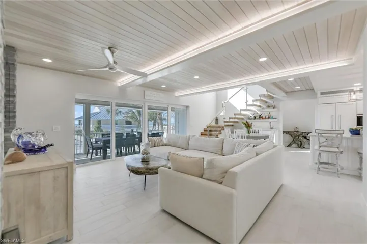 Living room with a wooden ceiling with exposed beams, recessed lighting, ceiling fan, stairs, and light wood-type flooring