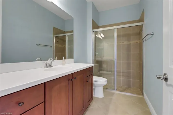 Full bath featuring vanity, a stall shower, and tile patterned flooring