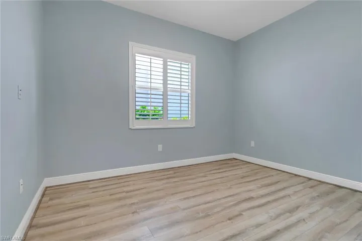 Bedroom featuring wood finished floors and baseboards