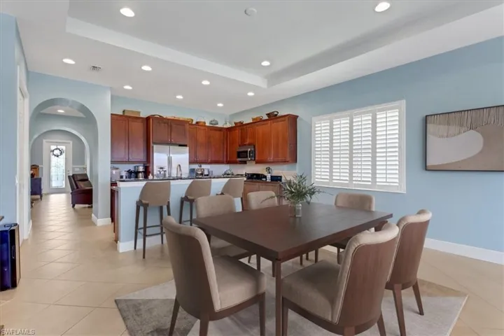 Virtually Staged Dining room with recessed lighting, a raised ceiling, light tile flooring, arched walkways, and baseboards