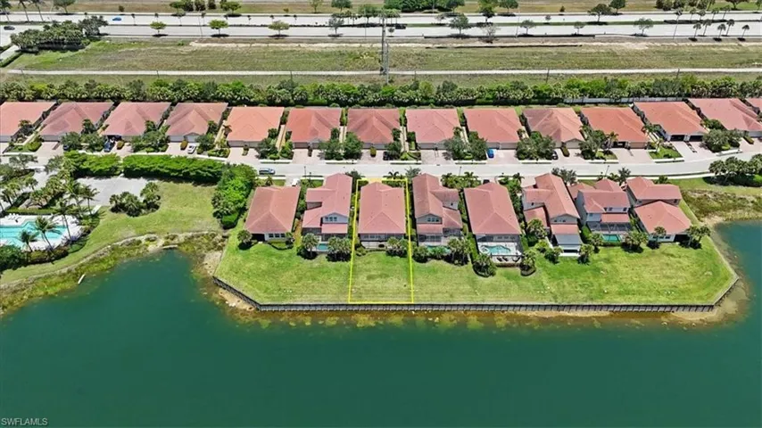 Aerial view of residential area featuring a nearby lake and property parcel outlined