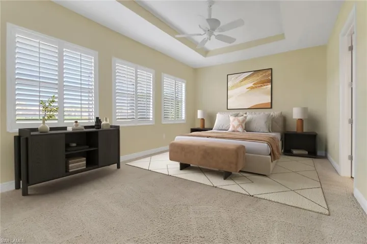Virtually Staged Bedroom with a tray ceiling, carpet flooring, and a ceiling fan