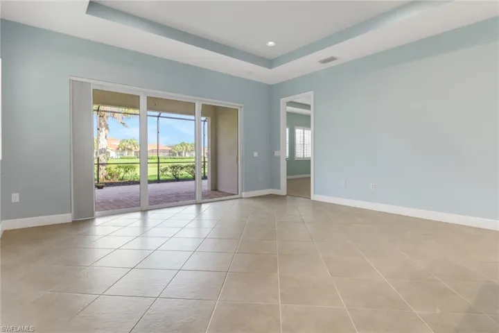 Livingroom featuring a raised ceiling, light tile patterned flooring, and recessed lighting