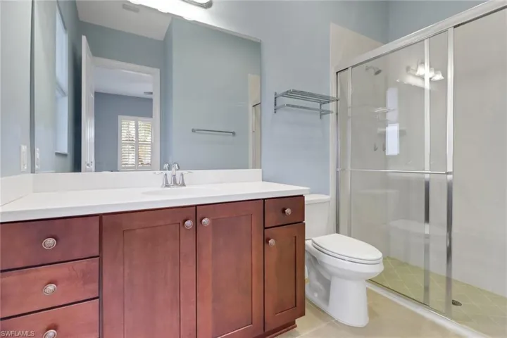 Full bath featuring a shower, vanity, and tile patterned floors
