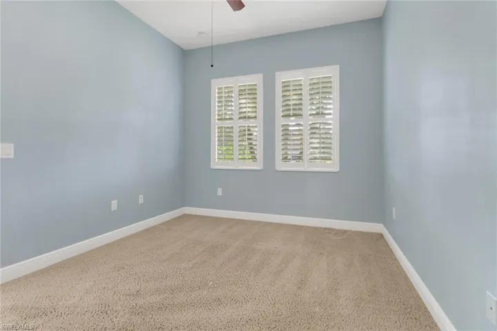 Large bedroom with baseboards and a ceiling fan