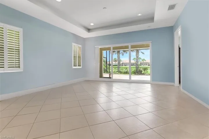 Tiled livingroom with baseboards, a tray ceiling, and recessed lighting