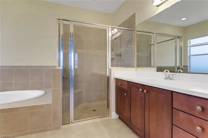 Bathroom featuring a stall shower, vanity, a bath, tile patterned flooring, and recessed lighting