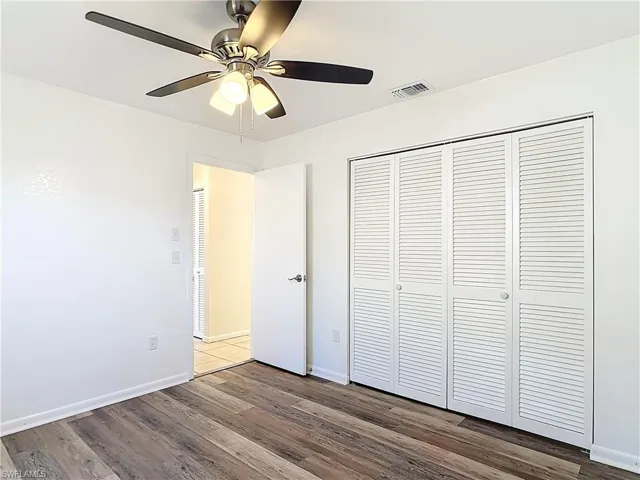 Unfurnished bedroom with wood finished floors, ceiling fan, and a closet