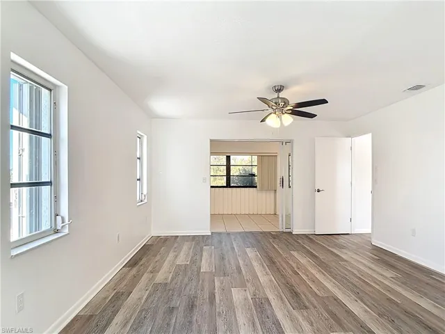 Unfurnished living room with wood finished floors and ceiling fan