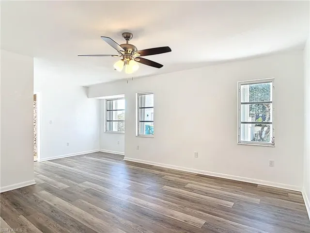 Unfurnished room with plenty of natural light, wood finished floors, and ceiling fan