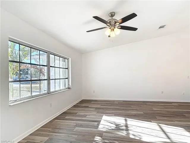 Spare room featuring lofted ceiling, wood finished floors, and ceiling fan