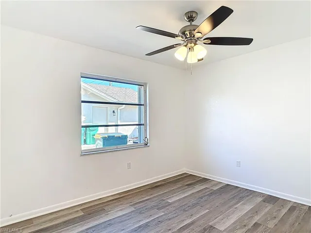 Empty room featuring wood finished floors and a ceiling fan