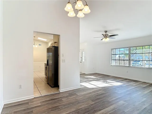 Unfurnished room featuring light wood-type flooring, a chandelier, and ceiling fan