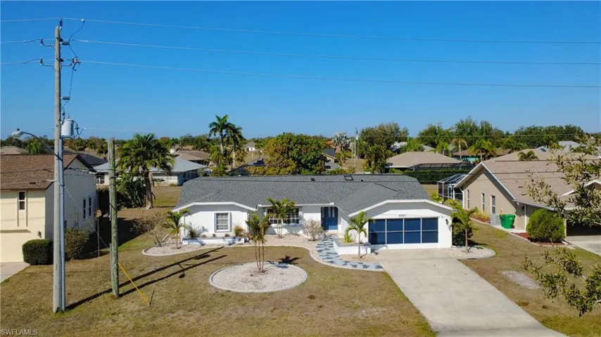 Ranch-style home with concrete driveway, a garage, a residential view, and a front yard