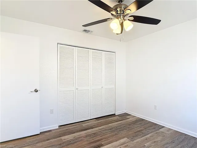 Unfurnished bedroom with dark wood finished floors, a closet, and ceiling fan