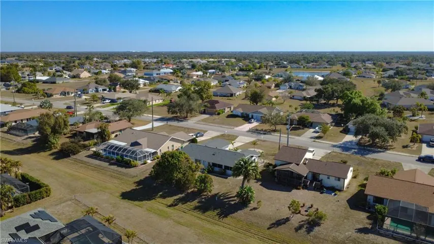 Aerial view of property and surrounding area with nearby suburban area