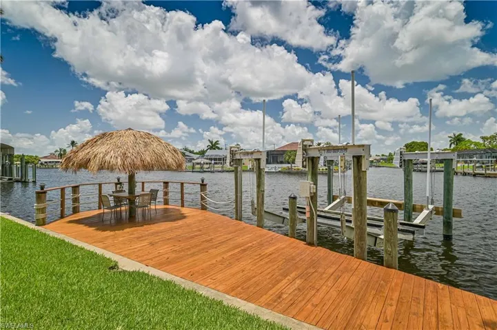 View of dock with boat lift and a water view