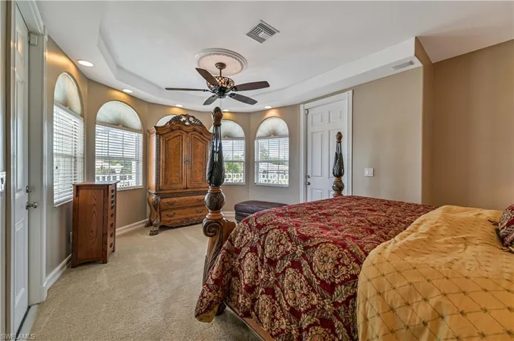 Bedroom with a ceiling fan, baseboards, visible vents, and light carpet