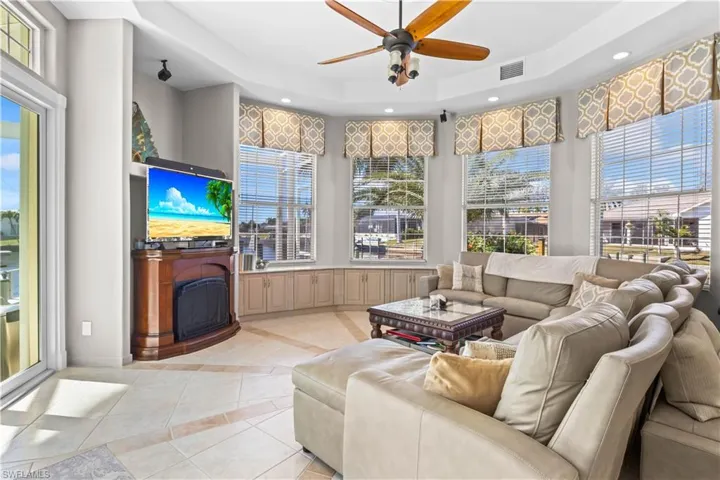 Living area featuring plenty of natural light, a fireplace, a raised ceiling, and visible vents