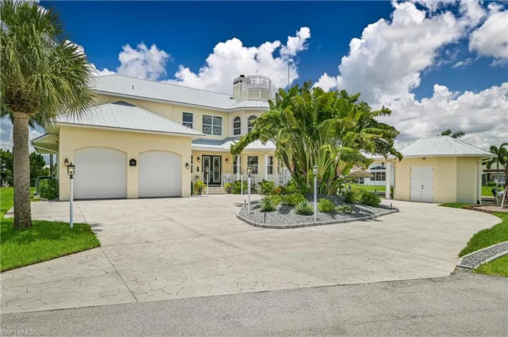 View of front of home featuring decorative driveway, metal roof, an attached garage, and stucco siding