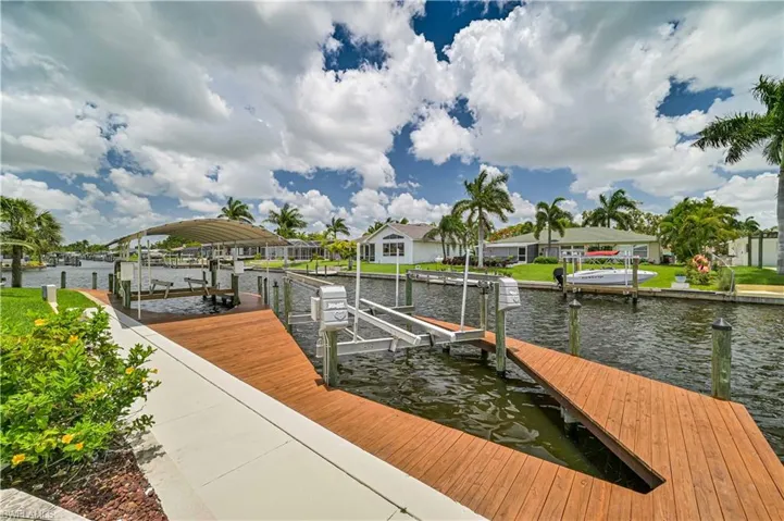 View of dock with a water view, a residential view, and boat lift