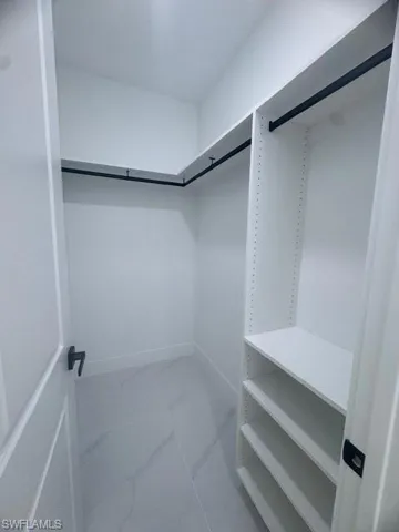 Walk in closet with marble finish flooring