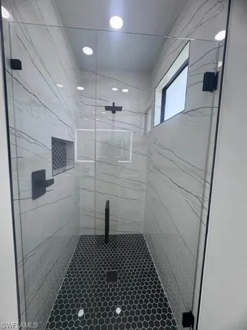 Full bath featuring a marble finish shower