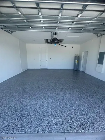 Garage featuring water heater and electric panel