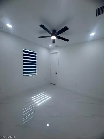 Unfurnished room with recessed lighting, light marble finish flooring, and ceiling fan