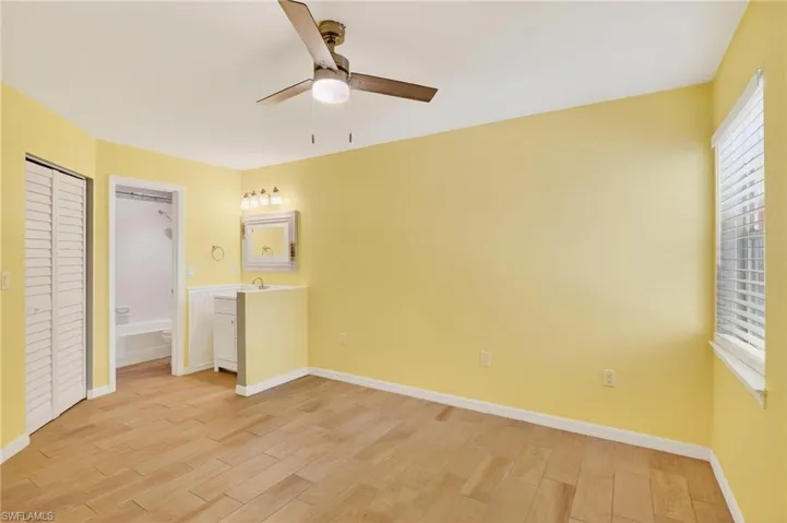 Unfurnished room featuring wood finish floors, healthy amount of natural light, and ceiling fan