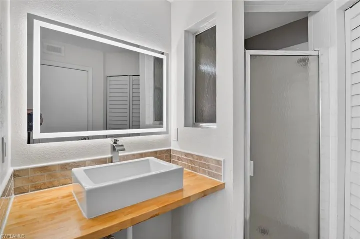 Rear view of house featuring a tiled roof and stucco siding