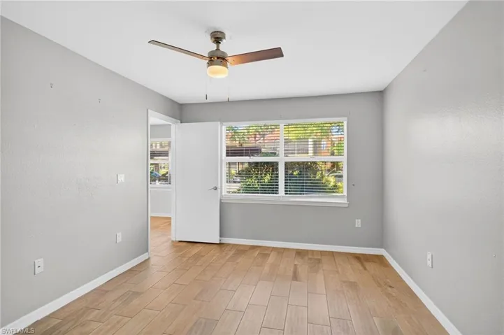 Carpeted living room featuring rail lighting, vaulted ceiling, and ceiling fan