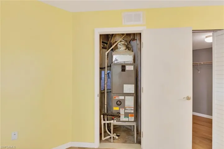 Bathroom featuring a textured wall, vanity, tasteful backsplash, a stall shower, and a closet
