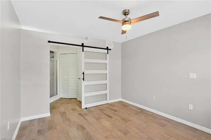 Bathroom with a textured wall and bathtub / shower combination