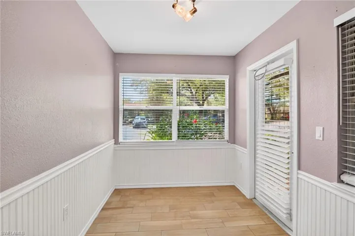 Kitchen with stainless steel appliances, white cabinets, light stone countertops, and a peninsula