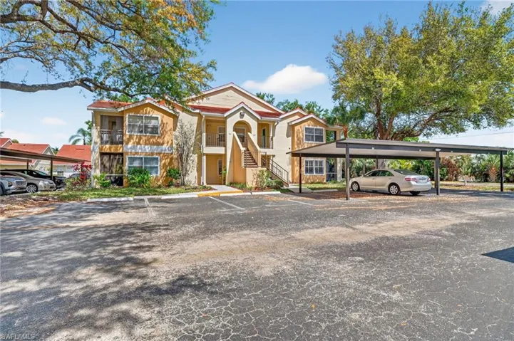 View of front of house with stairs and covered and uncovered parking