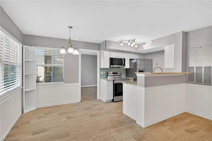 Unfurnished bedroom with light wood-style flooring, ensuite bathroom, a ceiling fan, and a closet